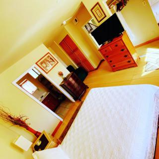Cozy bedroom with stylish furniture and a large television.