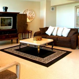 A cozy living room with a brown sofa, a marble-topped coffee table, and a television in the corner.