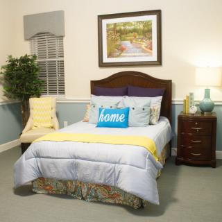 A cozy bedroom with a neatly made bed, accent pillows, and a welcoming ambiance.