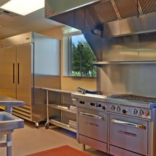 A modern commercial kitchen equipped with stainless steel appliances and industrial cooking equipment.