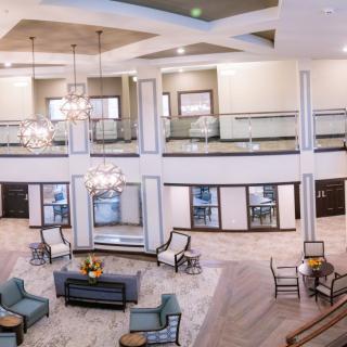 A spacious, elegantly designed lobby featuring chandeliers and comfortable seating areas.