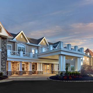 A beautifully designed residential building with a grand entrance at dusk.