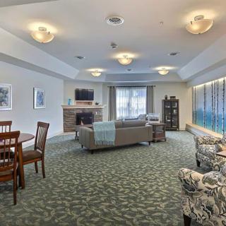 A spacious living room with a comfortable seating area and large windows.