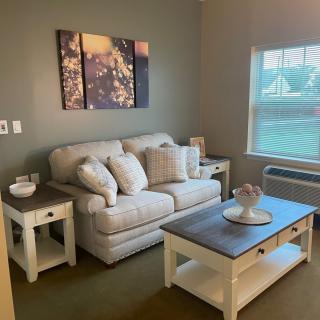 A cozy living room with a sofa, side tables, and coffee table.