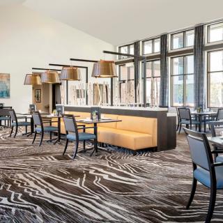 A modern restaurant dining area with stylish furniture and large windows.
