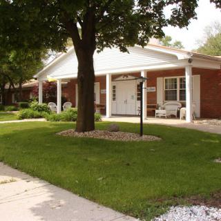A charming brick building surrounded by greenery and well-kept landscaping.