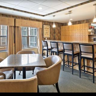 A modern kitchen with a bar and dining area featuring wood paneling and stylish lighting.