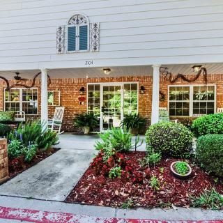 A well-maintained building entrance with a landscaped garden and a welcoming porch.