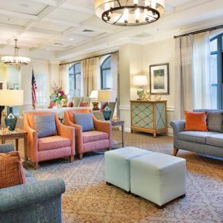 A well-appointed living room with modern furniture and elegant chandeliers.