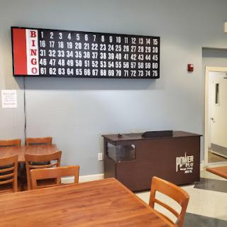 A cozy bingo hall featuring a large bingo board and seating for players.