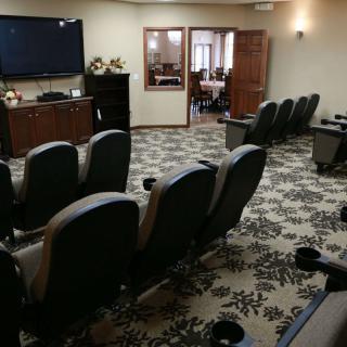 A cozy home theater setup with comfortable seating and a large screen for viewing.