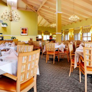 A cozy restaurant dining area with neatly arranged tables and elegant chandeliers.