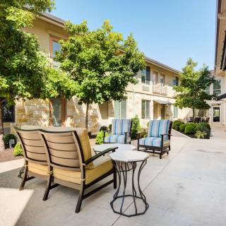 A sunny outdoor patio area with comfortable seating and lush greenery.