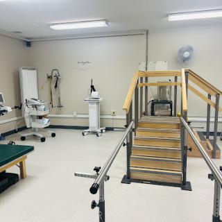 A well-equipped physical therapy room featuring a set of training stairs and various rehabilitation tools.