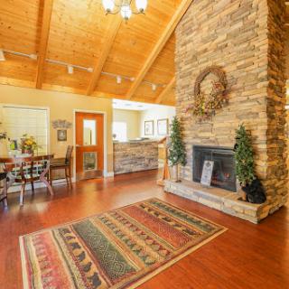 A cozy living room featuring a stone fireplace, wooden ceilings, and an inviting atmosphere.