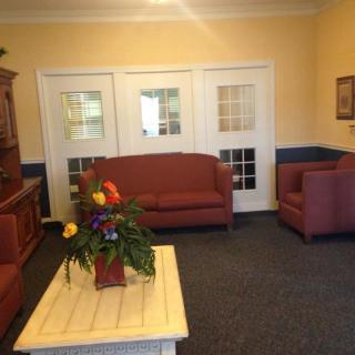 A cozy living room with a sofa set, coffee table, and floral arrangement.