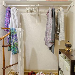A neatly organized closet with clothes hanging on hangers.