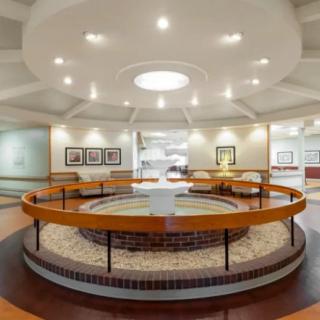 A modern lobby interior featuring a circular structure and prominent ceiling lighting.
