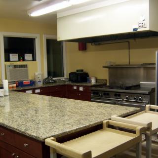 A spacious kitchen with a granite countertop and modern appliances.
