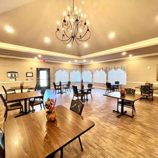 A spacious dining room with elegant lighting and neatly arranged tables.