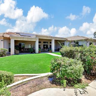 A beautiful house with a well-maintained garden under a clear blue sky.
