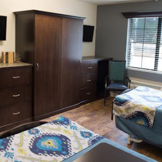 A well-furnished bedroom featuring a combination of modern storage solutions and comfortable seating.