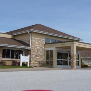 A modern building with a stone facade and glass entrance.