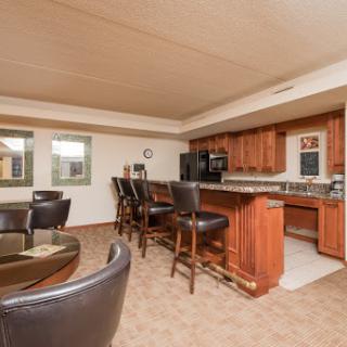 A modern kitchen and dining area featuring wooden cabinetry and bar seating.