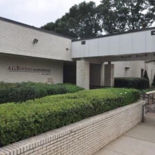Exterior view of a brick building surrounded by greenery.