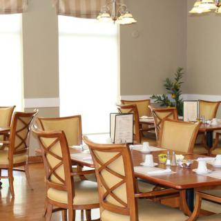 A well-lit restaurant dining area with neatly arranged tables and chairs.