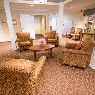 A cozy living room with patterned armchairs arranged around a wooden coffee table.