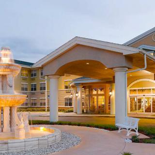 An elegant building entrance with a fountain and columns.