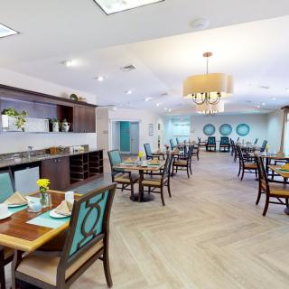 A modern dining room interior with neatly arranged tables and chairs, featuring stylish decor.