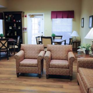 A cozy living room with patterned chairs, a round table, and soft lighting.