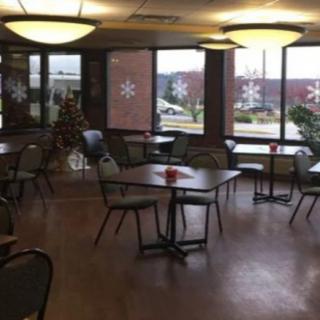 An empty cafe with decorated windows and neatly arranged tables and chairs.