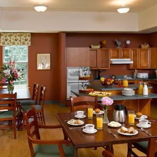 A cozy kitchen and dining area with breakfast setup including orange juice and coffee.
