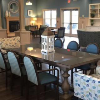 A cozy dining area with a large table and chairs, complemented by a decorative lantern at the center.