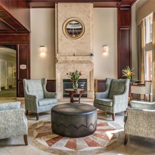 A cozy living room with elegant seating arranged around a fireplace, complemented by a stylish coffee table and decorative accents.
