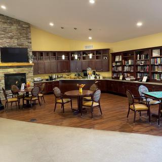 A cozy library with bookshelves, a fireplace, and seating area.