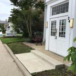 A welcoming entrance with a bench and landscaped area.