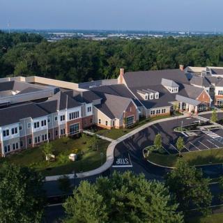 Aerial view of a large residential building surrounded by lush greenery.