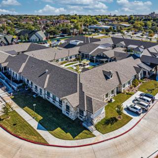 Aerial view of a suburban residential complex with multiple buildings and parking spaces.