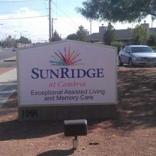 A sign for SunRidge Assisted Living and Memory Care beside a road.