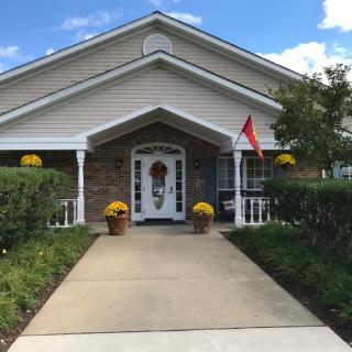 A cozy house with a welcoming entrance, lined with flowers and a small flag on the porch.