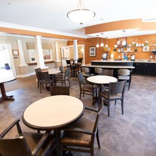 A modern cafÃ© interior with tables, chairs, and a bar area under bright lighting.