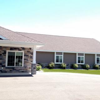 A commercial building on a sunny day with a large driveway.