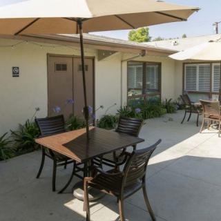 A cozy outdoor patio area with tables, chairs, and umbrellas.