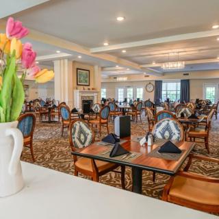 An elegant dining room with neatly set tables and colorful flower decorations.