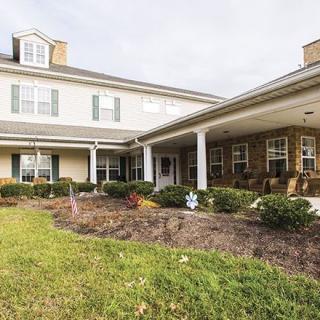 A two-story house with a wide porch and well-maintained lawn.