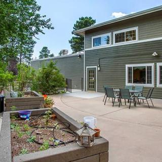 A spacious patio area with outdoor furniture and garden planters.